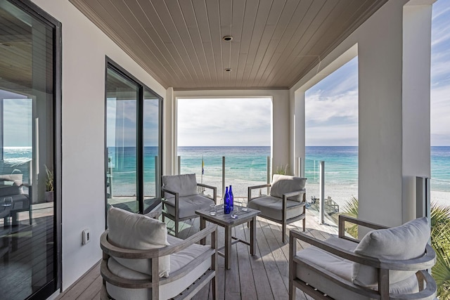 balcony featuring a beach view and a water view