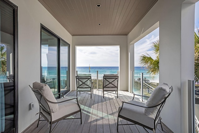 balcony with a water view and a beach view