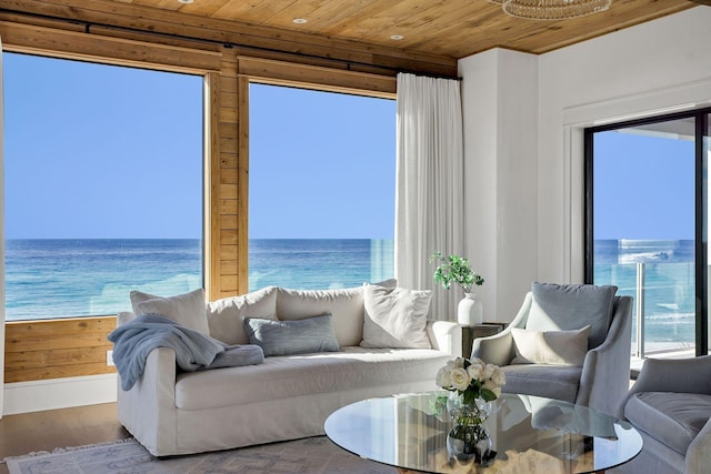 living room featuring wooden ceiling, wood finished floors, and a water view