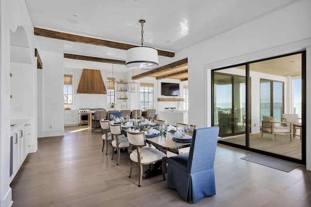 dining area with wood finished floors and beamed ceiling