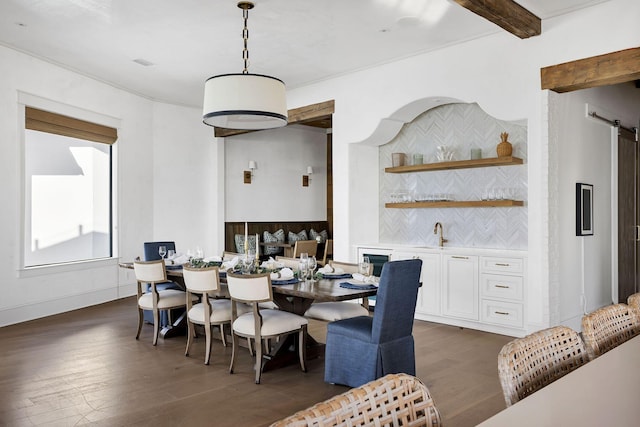 dining area featuring dark wood-style flooring, indoor wet bar, and beam ceiling