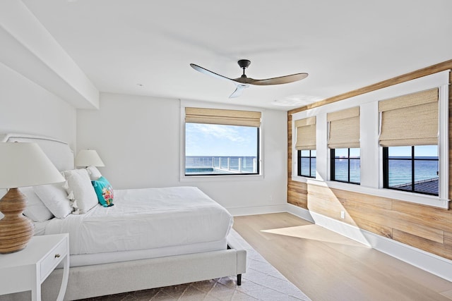 bedroom featuring ceiling fan, wood finished floors, and baseboards