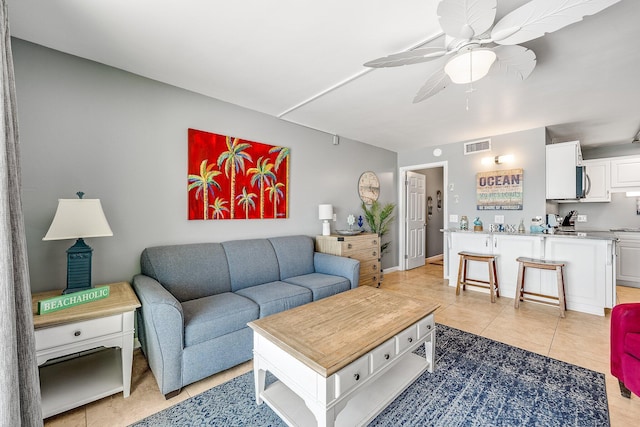 living room featuring a ceiling fan, visible vents, and light tile patterned flooring