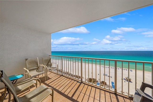 balcony featuring a water view and a beach view