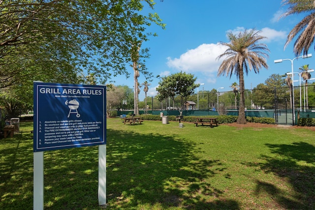 view of home's community featuring a lawn and fence