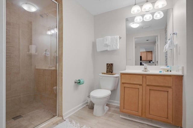 full bath with toilet, a stall shower, wood finished floors, and vanity