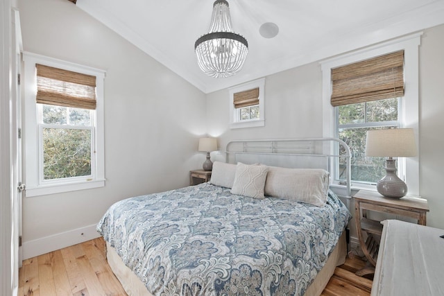 35 Tupelo St, Santa Rosa Beach, FL 32459 - bedroom with baseboards, lofted ceiling, a notable chandelier, and wood finished floors