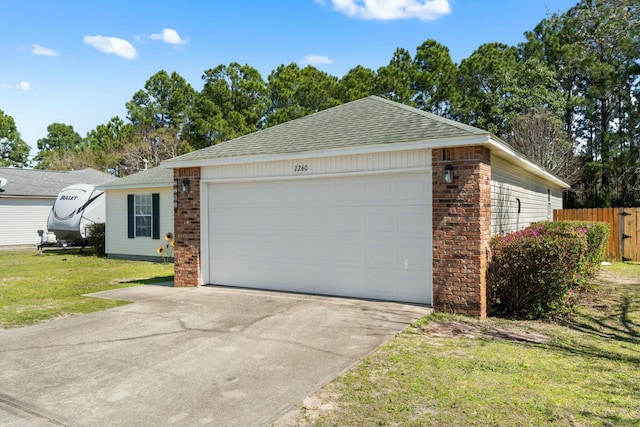 garage featuring concrete driveway and fence