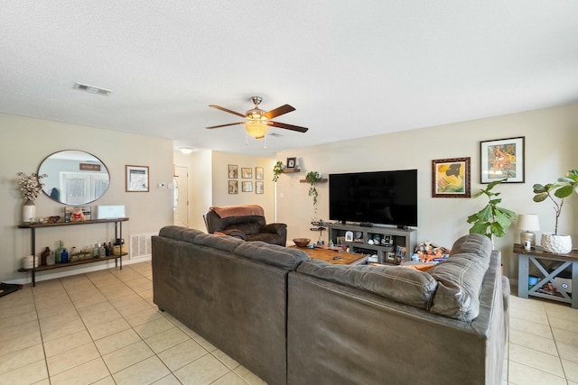 living room with light tile patterned floors, visible vents, and ceiling fan