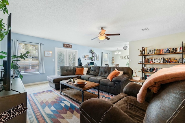 living room featuring ceiling fan, visible vents, a textured ceiling, and light tile patterned flooring