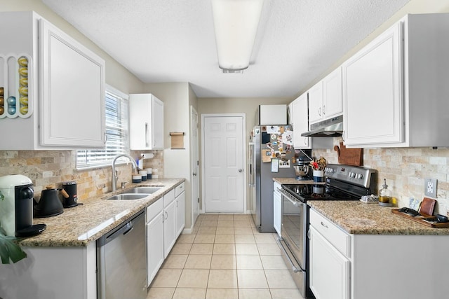 kitchen featuring under cabinet range hood, appliances with stainless steel finishes, light tile patterned flooring, white cabinetry, and a sink