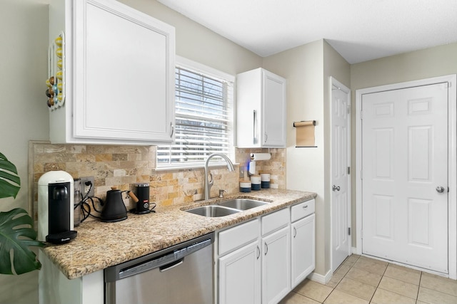 kitchen with backsplash, dishwasher, light tile patterned flooring, white cabinets, and a sink