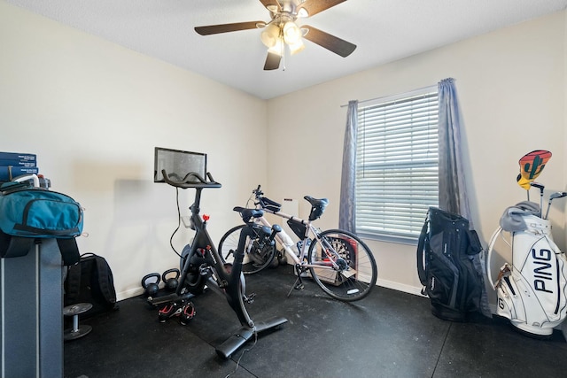 workout room featuring a ceiling fan and baseboards