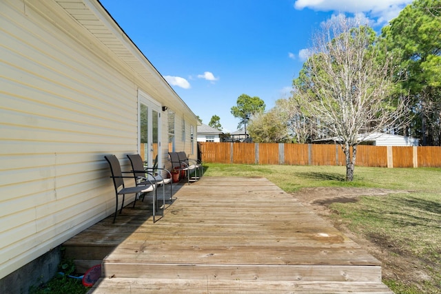 wooden deck with fence and a lawn