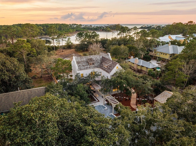 aerial view at dusk featuring a water view