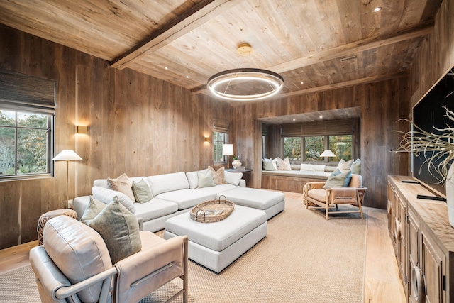 living room with wooden walls, beamed ceiling, wooden ceiling, and light wood-style floors