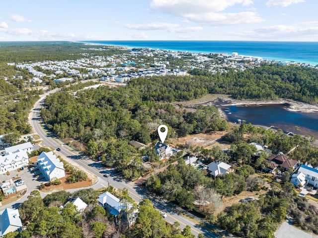 aerial view featuring a forest view and a water view