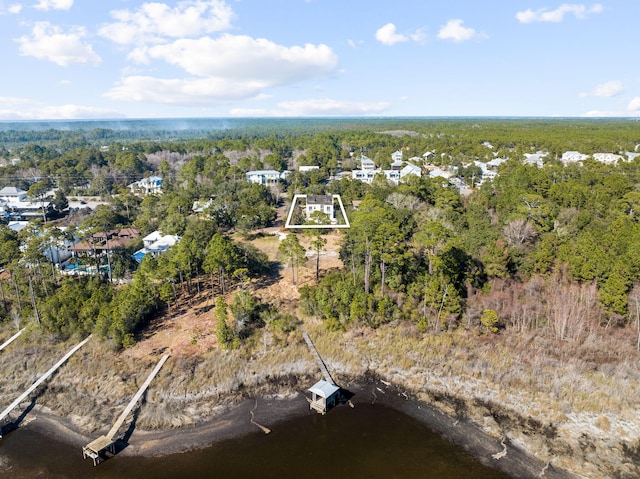 aerial view featuring a wooded view and a water view
