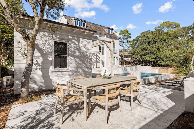 view of patio featuring outdoor dining space, a fenced in pool, and fence