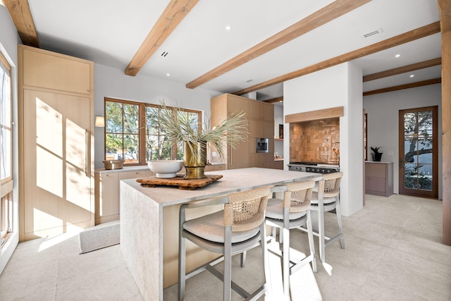 kitchen featuring recessed lighting, a kitchen island, visible vents, beamed ceiling, and decorative backsplash
