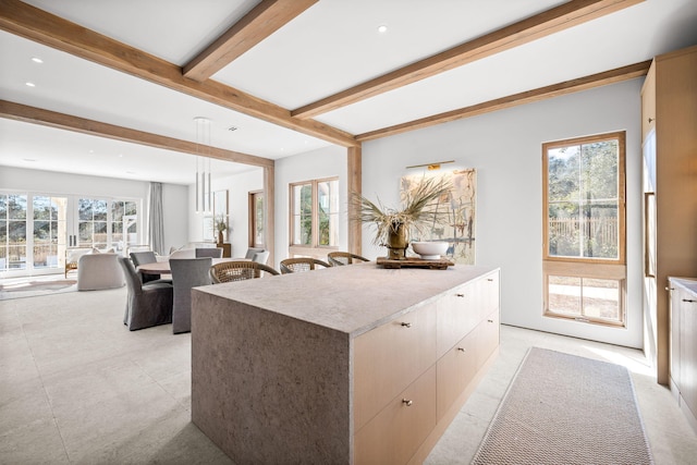 kitchen featuring pendant lighting, beamed ceiling, modern cabinets, recessed lighting, and open floor plan