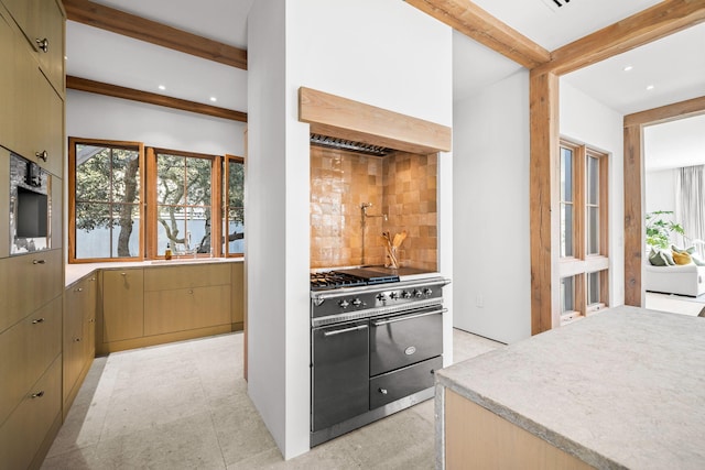 kitchen with beamed ceiling, tasteful backsplash, recessed lighting, light countertops, and range with two ovens
