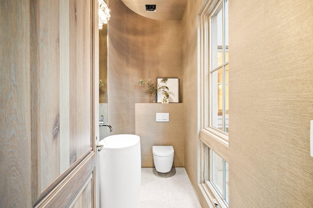 bathroom with toilet and a high ceiling