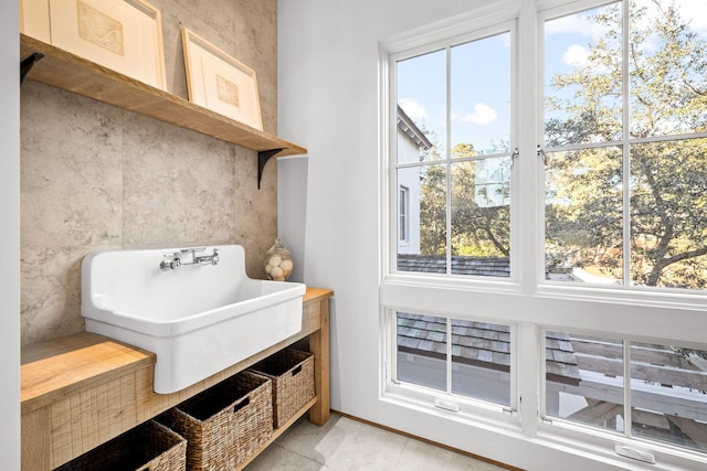 mudroom featuring a sink, baseboards, and plenty of natural light