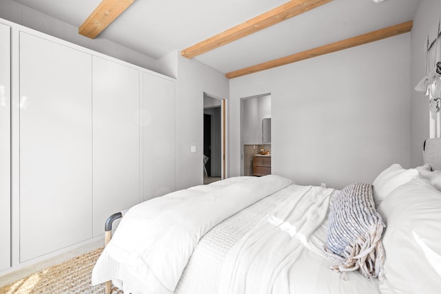 bedroom with a closet and beamed ceiling