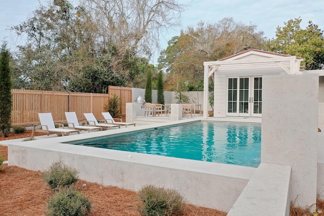 view of pool featuring a fenced in pool, an outdoor structure, a patio area, a fenced backyard, and a storage structure