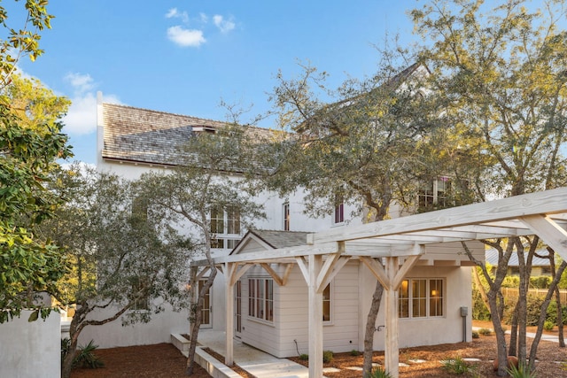 view of property exterior with stucco siding and roof with shingles