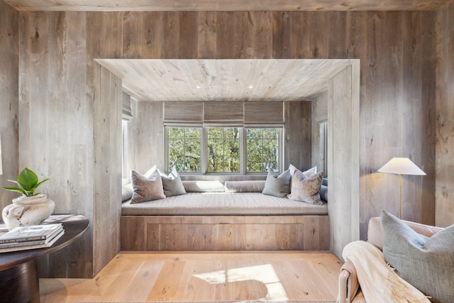 living area featuring wood walls and hardwood / wood-style floors