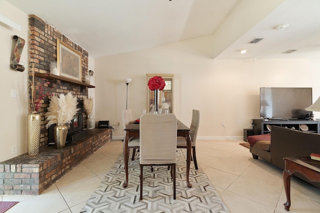 dining room featuring light tile patterned floors, visible vents, baseboards, and vaulted ceiling