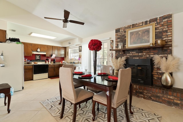 dining area featuring light tile patterned flooring, a ceiling fan, and vaulted ceiling