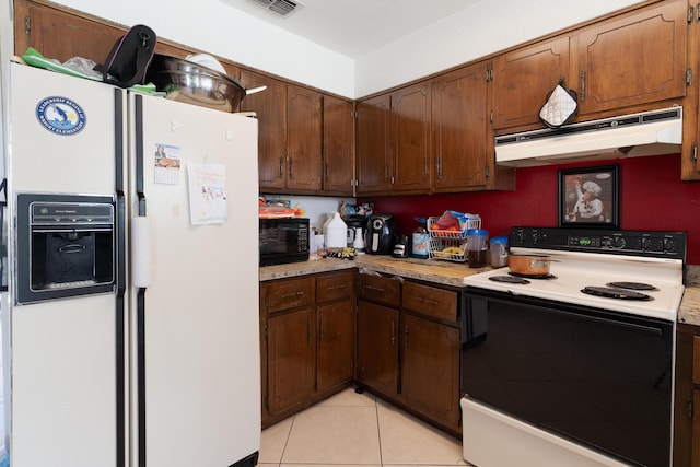 kitchen featuring range with electric cooktop, under cabinet range hood, white refrigerator with ice dispenser, black microwave, and light tile patterned floors