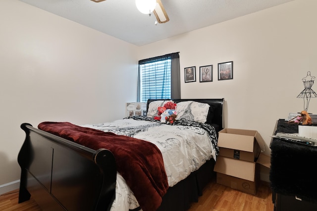 bedroom with ceiling fan, baseboards, and light wood-style flooring