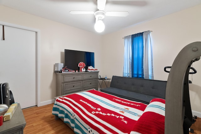 bedroom with a ceiling fan, wood finished floors, and baseboards