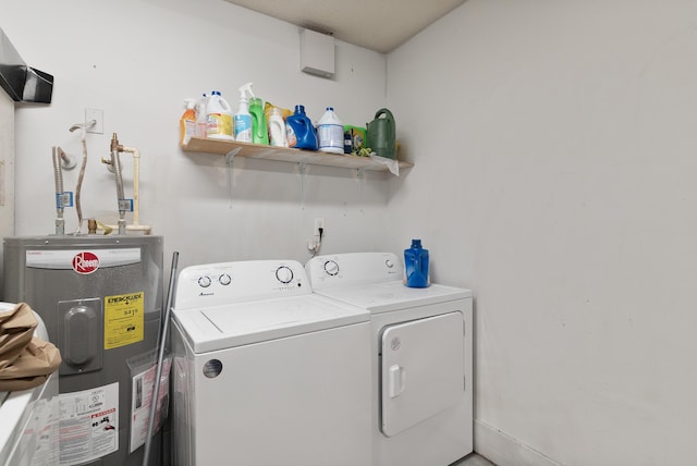 washroom featuring washing machine and dryer, water heater, and laundry area