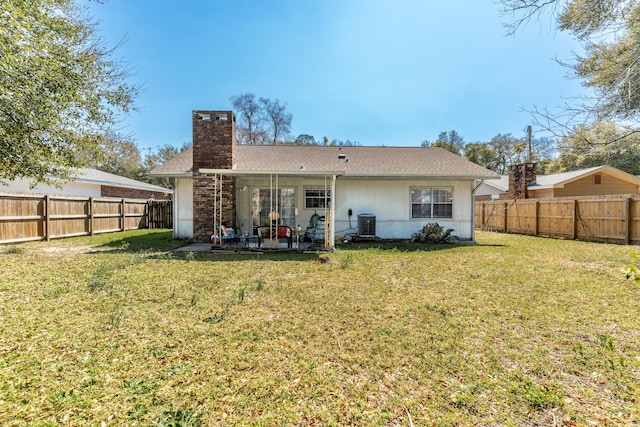 rear view of house featuring a fenced backyard, central AC, a chimney, a patio area, and a lawn