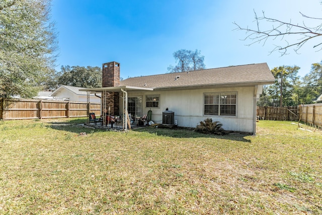 rear view of house featuring a yard, cooling unit, a fenced backyard, and a chimney