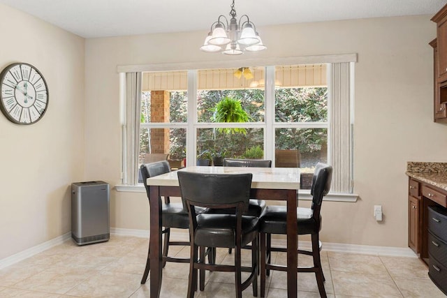 dining area featuring a healthy amount of sunlight, light tile patterned floors, baseboards, and a notable chandelier