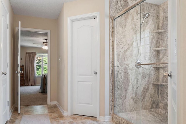 ensuite bathroom with connected bathroom, a marble finish shower, baseboards, and a textured ceiling