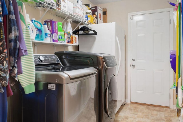 washroom featuring laundry area, independent washer and dryer, and stone finish flooring