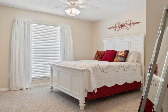 bedroom with ceiling fan, baseboards, and light colored carpet