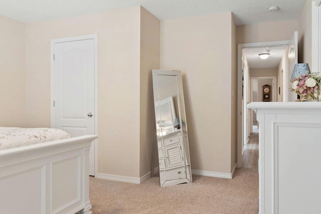 bedroom featuring light carpet and baseboards