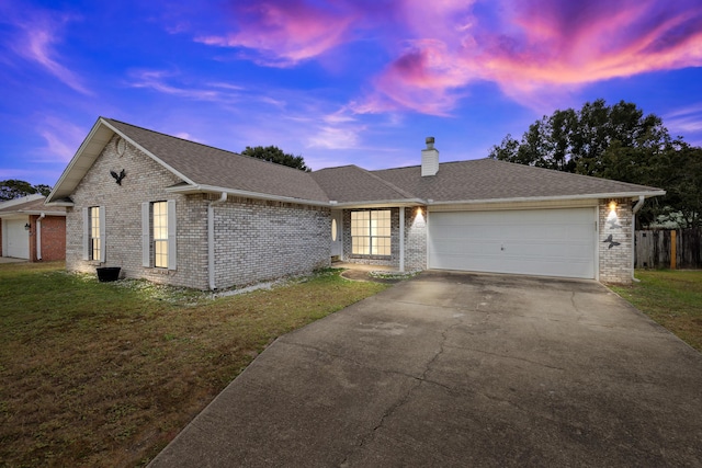 single story home featuring a garage, concrete driveway, a chimney, a front lawn, and brick siding