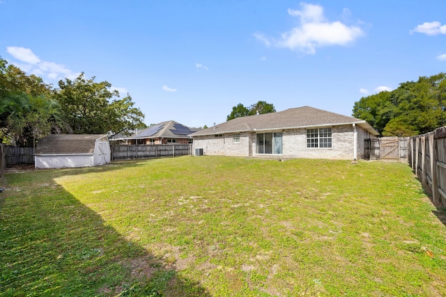 view of yard featuring a storage shed, a fenced backyard, and an outdoor structure