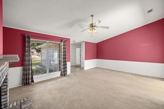 unfurnished living room featuring ceiling fan, a textured ceiling, carpet, and visible vents