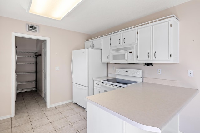 kitchen with light countertops, white cabinetry, light tile patterned flooring, white appliances, and a peninsula