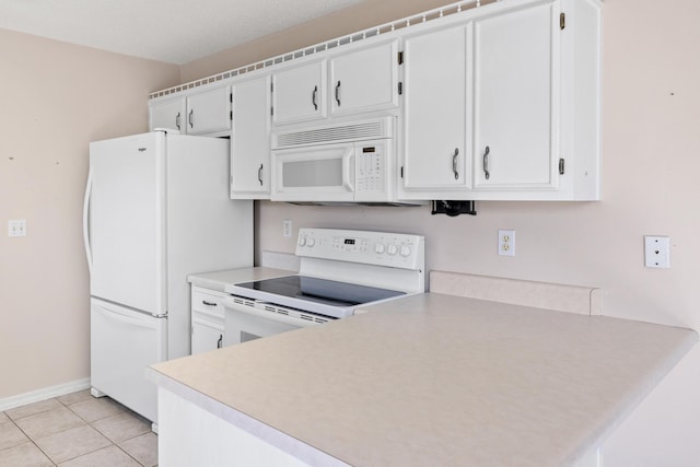 kitchen with light tile patterned floors, light countertops, white cabinets, white appliances, and baseboards